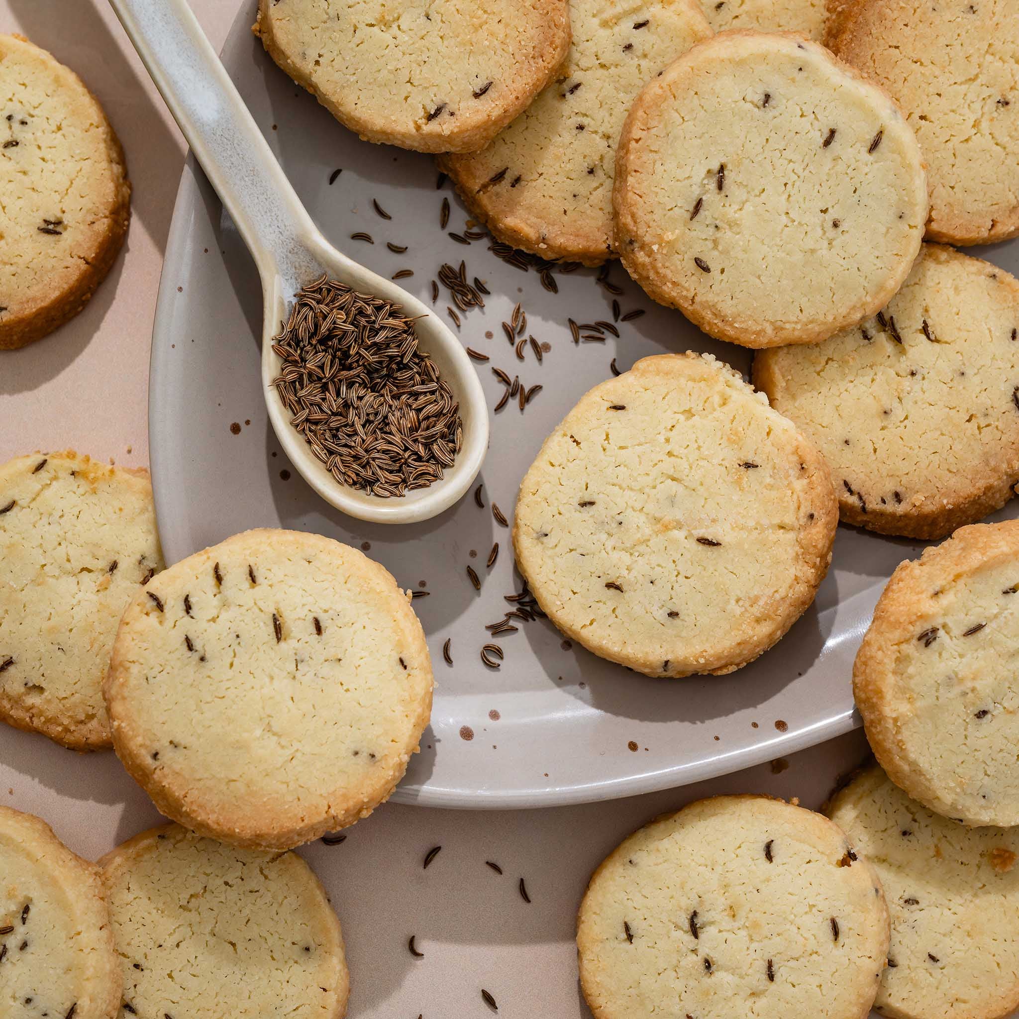 Shortbread cookies with caraway seeds on a plate and spoon