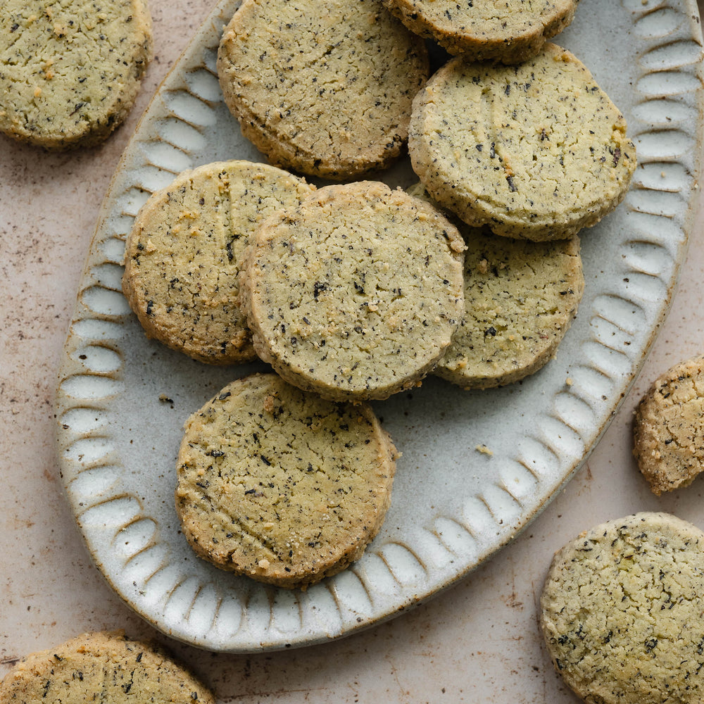 Round earlgrey shortbread on a decorative ceramic plate with a beige background