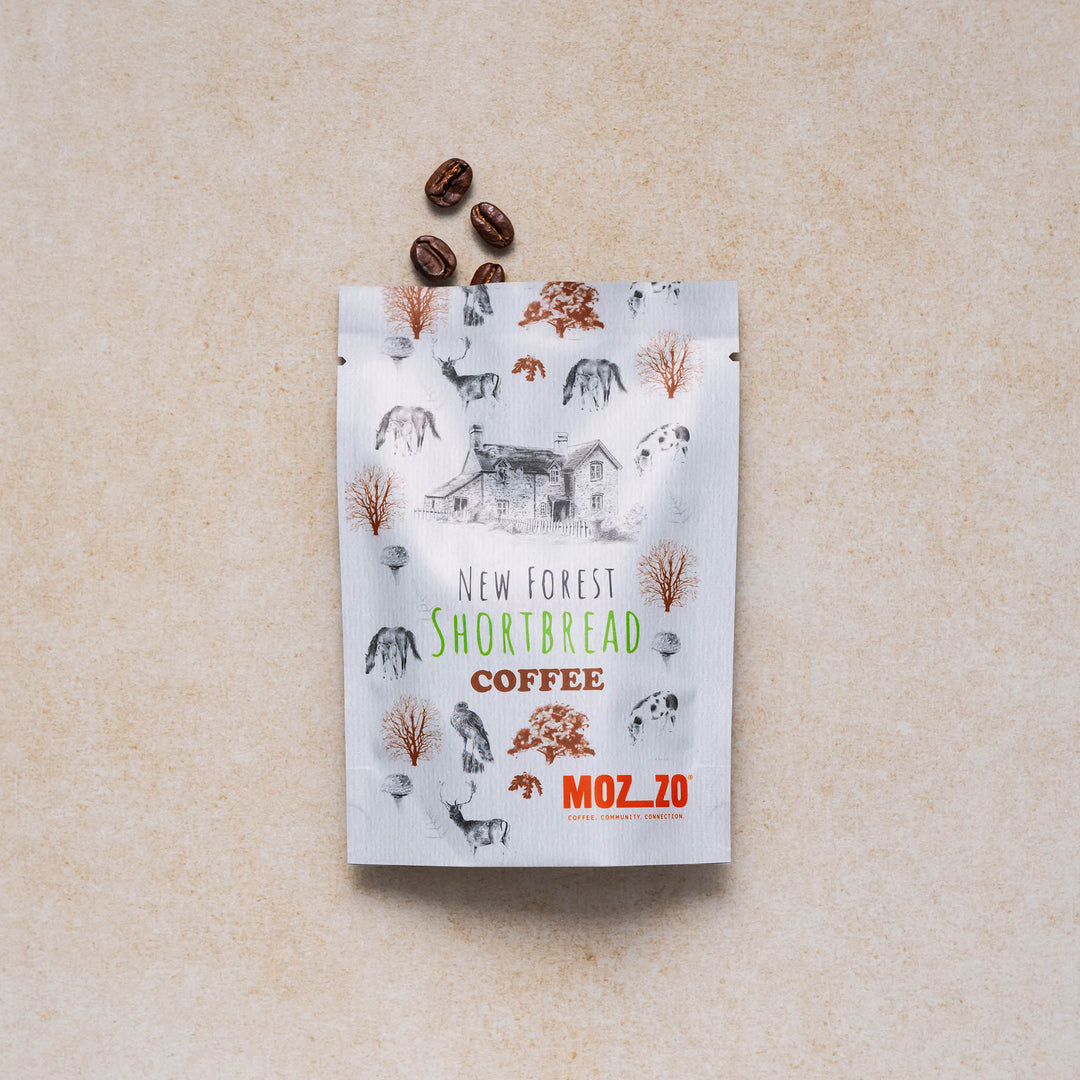 New Forest shortbread coffee snack pack with a display of coffee beans on a neutral backdrop