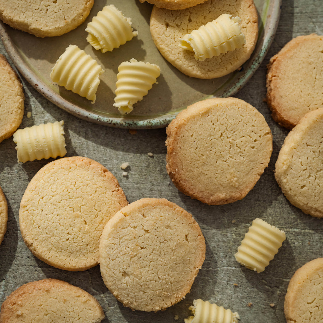 Buttery shortbread with curled shreds of butter on a stone plate on a rustic surface