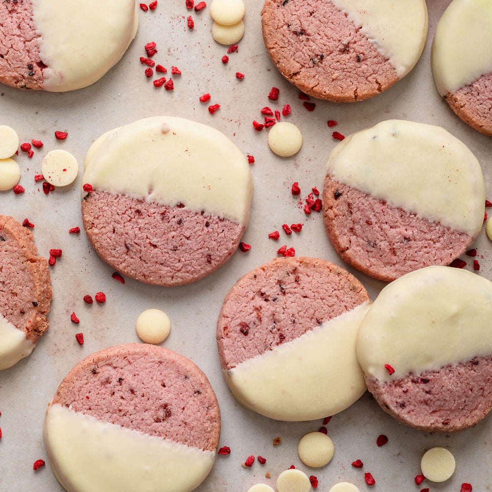 Shortbread with pink and white halves and freeze-dried raspberry sprinkles on a light background