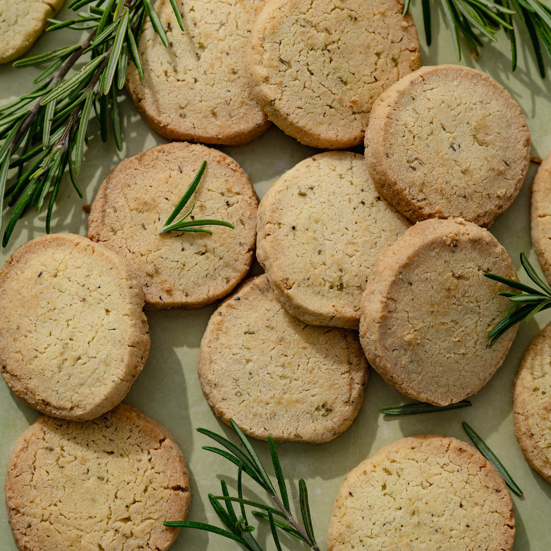 Round shortbread with rosemary sprigs on a light surface